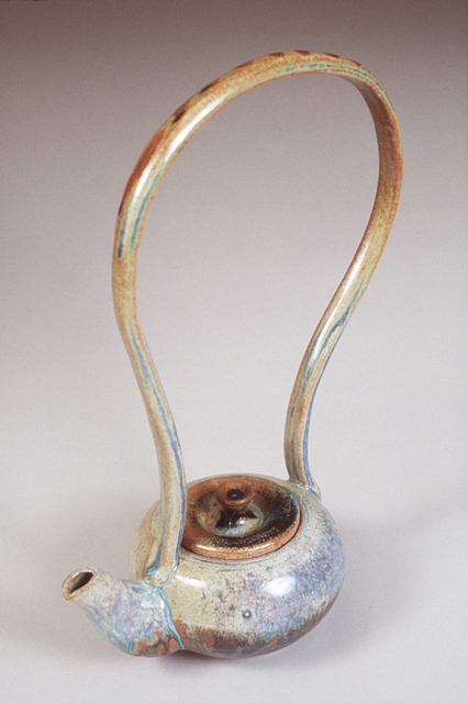A teapot with an extremely long handle